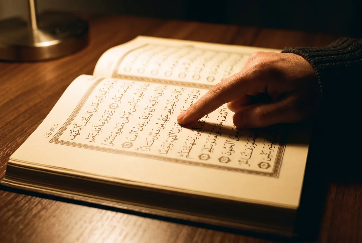 Resources A close view of an open mushaf, the script catching low warm light.